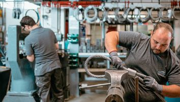 Zwei Männer beim Vorbereiten und Verpressen von Drahtseilaugen