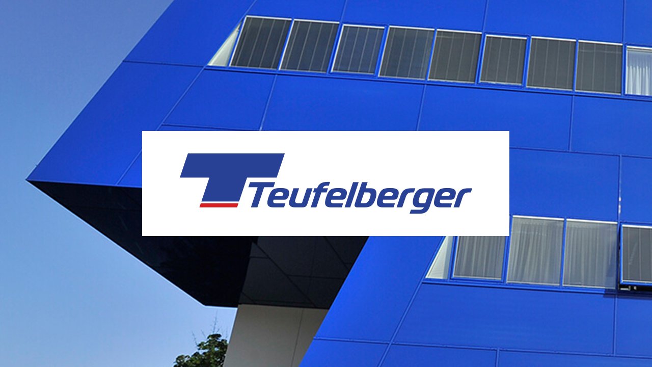 Blaues Gebäude mit Fensterreihe und der Aufschrift Teufelberger.