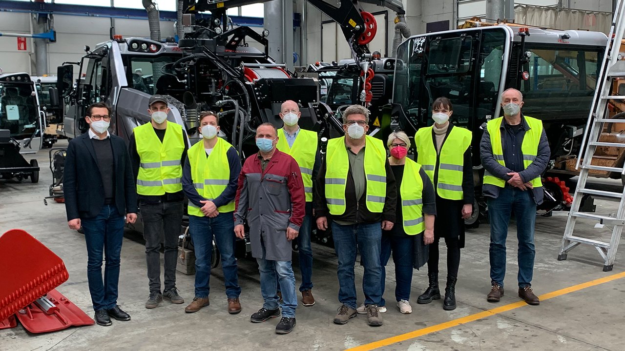 Gruppenbild der Vorstandsmitglieder des Bundesverbands in Warnwesten und mit Schutzmasken vor Spezialfahrzeugen.
